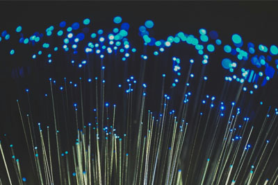 Glowing fiber optic strands, showcasing the durability and strength of fiber optic cables in data transmission.